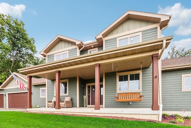 craftsman inspired home featuring a garage, covered porch, and a front lawn