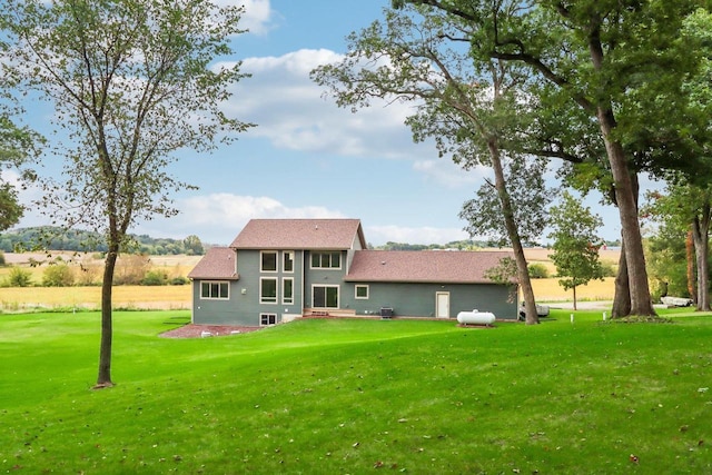 rear view of house featuring a yard