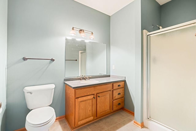 bathroom featuring tile patterned flooring, vanity, a shower with shower door, and toilet