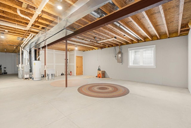 basement with heating unit, gas water heater, and electric panel