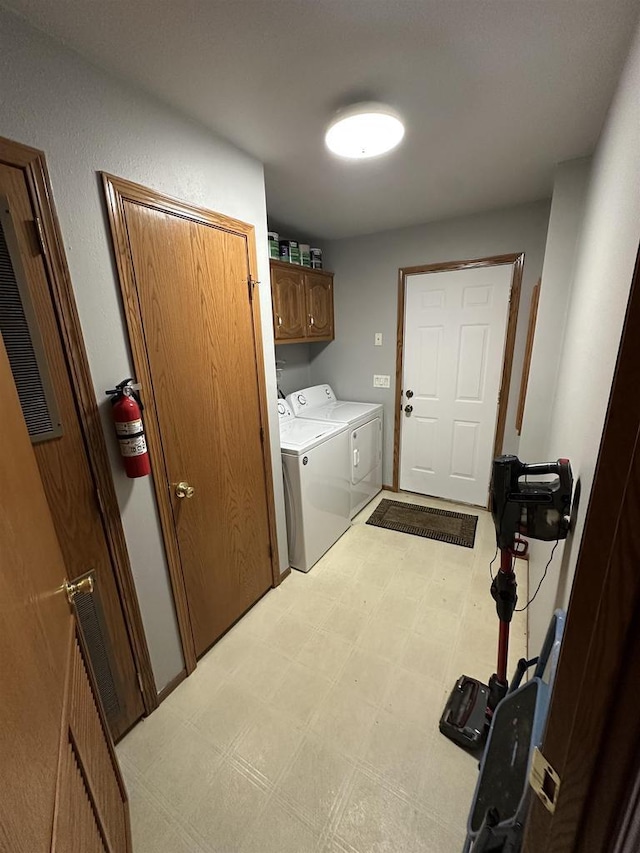 laundry area featuring cabinets and washing machine and clothes dryer