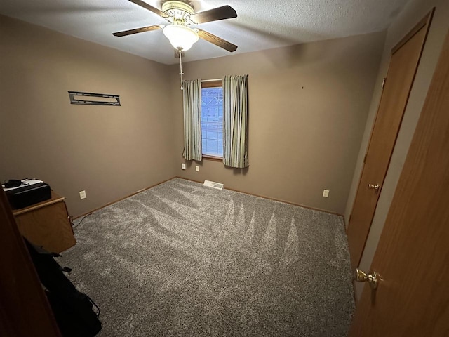 spare room with ceiling fan, carpet, and a textured ceiling