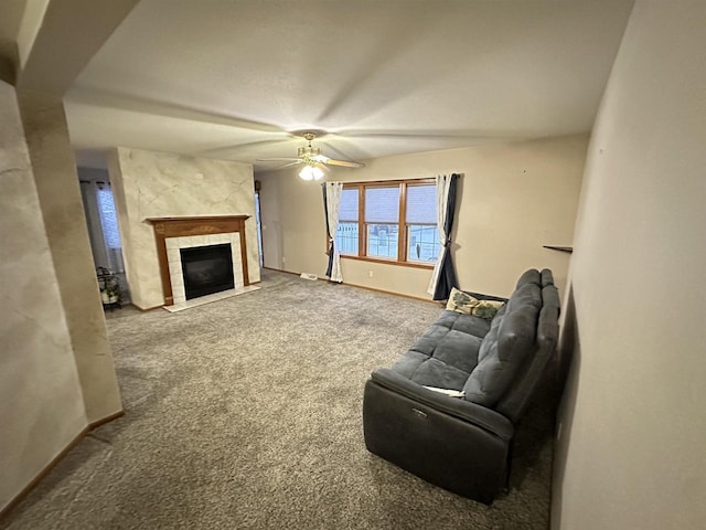 living room with ceiling fan, carpet flooring, and a tiled fireplace