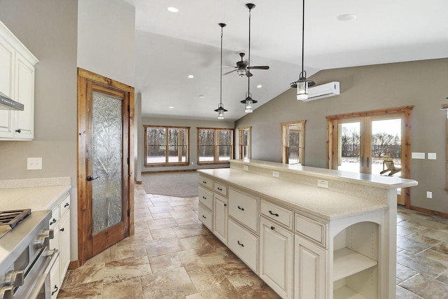 kitchen with vaulted ceiling, hanging light fixtures, high end stainless steel range oven, a center island, and french doors