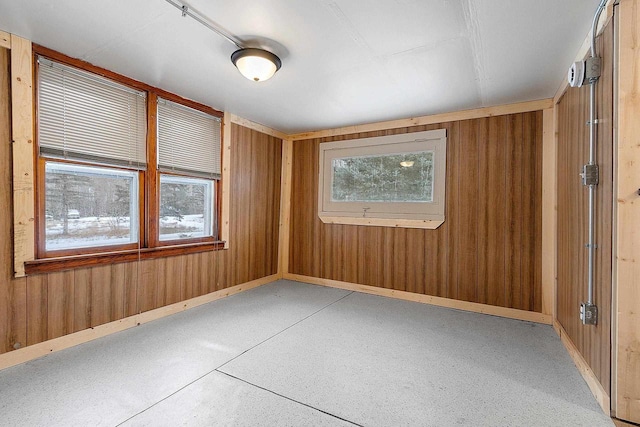 unfurnished room featuring wooden walls