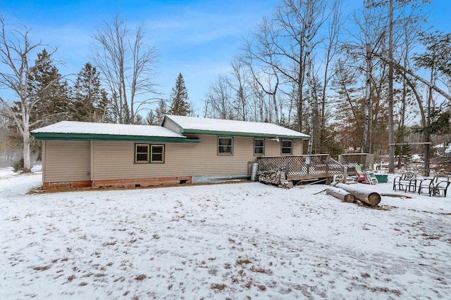 snow covered back of property featuring a wooden deck