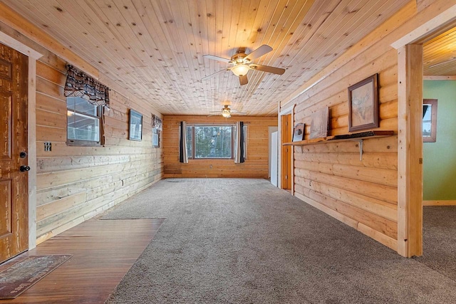 empty room featuring carpet flooring, wooden walls, and wood ceiling