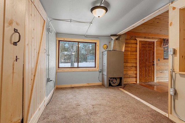 interior space with heating unit, rustic walls, and wood walls