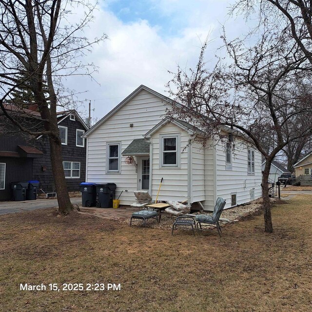 rear view of property featuring a lawn