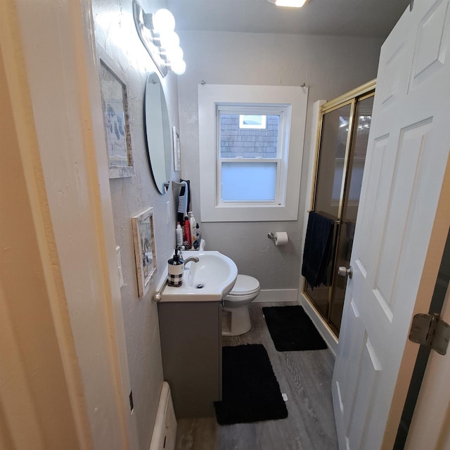 bathroom featuring vanity, toilet, hardwood / wood-style floors, and walk in shower