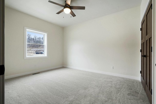 empty room with ceiling fan and light colored carpet