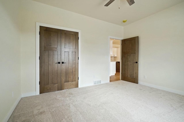 unfurnished bedroom with a closet, ceiling fan, and carpet