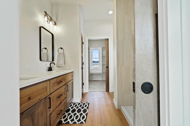 bathroom featuring vanity, a shower, and wood-type flooring