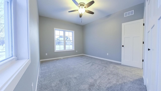 carpeted spare room featuring ceiling fan