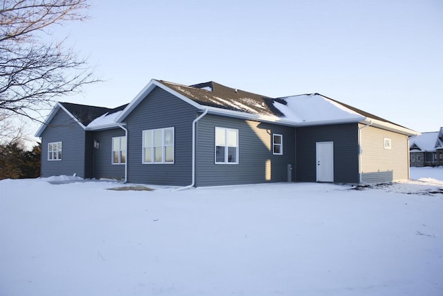 view of snow covered rear of property