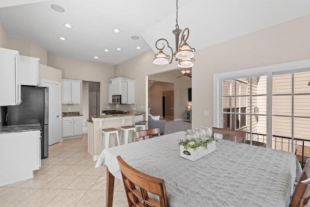 dining room featuring lofted ceiling, light tile patterned floors, and a chandelier