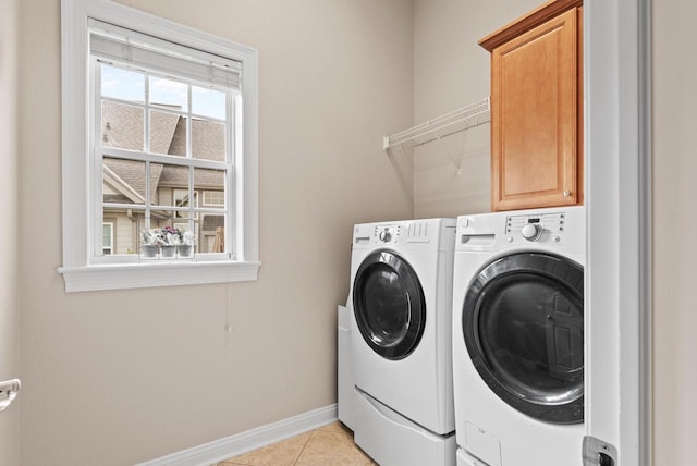 washroom with washing machine and dryer, cabinets, and light tile patterned flooring