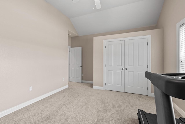 interior space with lofted ceiling, light carpet, and ceiling fan