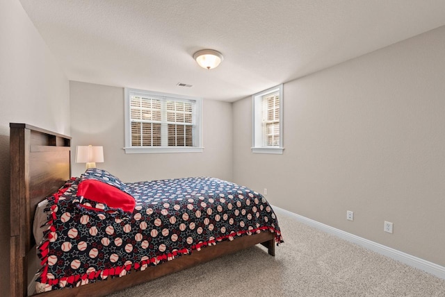 bedroom featuring a textured ceiling and carpet flooring