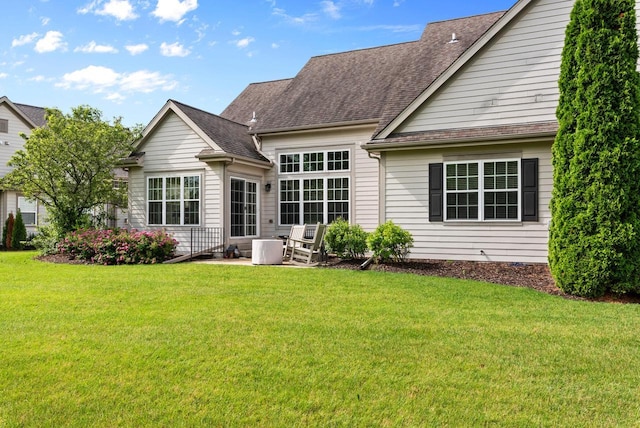 rear view of property featuring a patio and a lawn