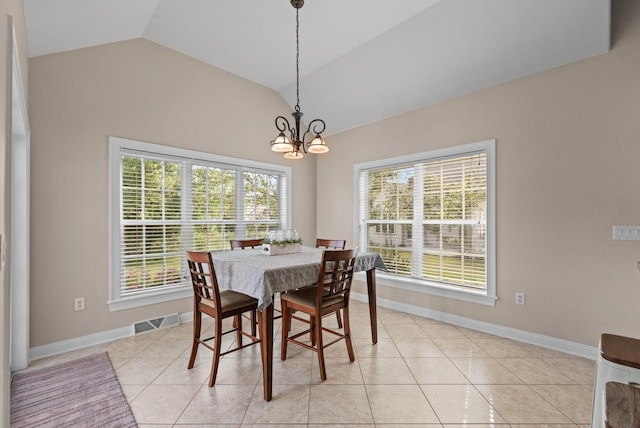 tiled dining room with vaulted ceiling and an inviting chandelier