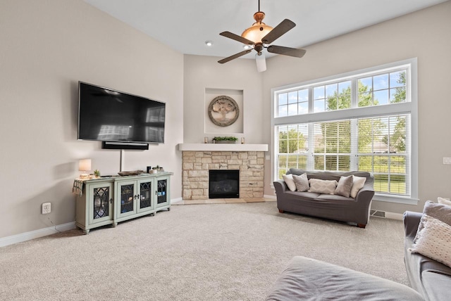 carpeted living room with ceiling fan and a fireplace