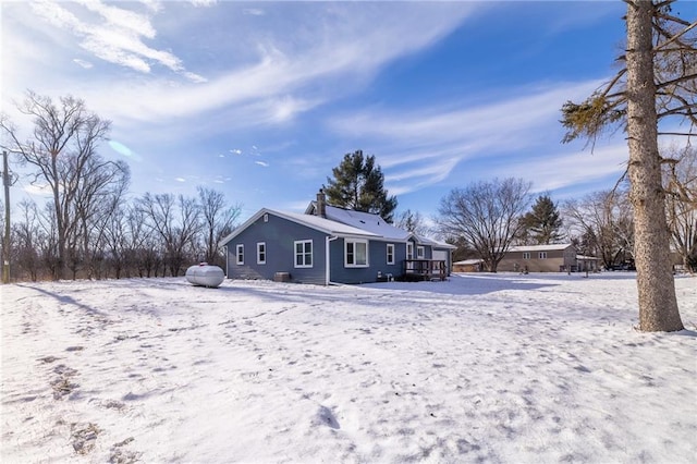 snow covered house featuring a wooden deck