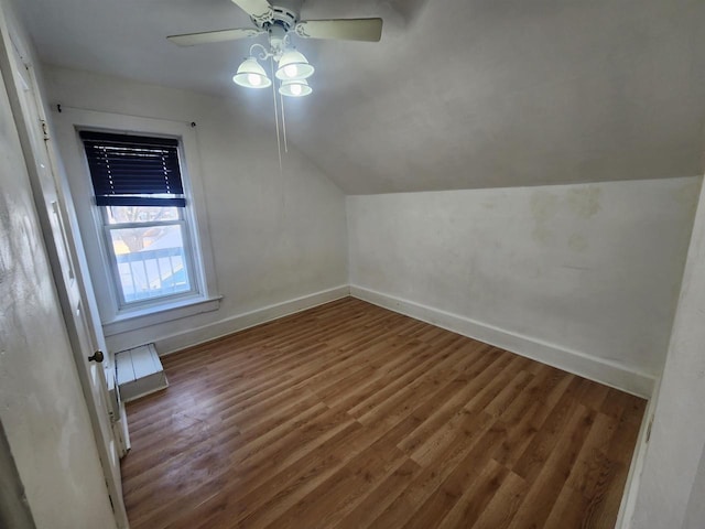 additional living space with ceiling fan, lofted ceiling, and dark hardwood / wood-style flooring