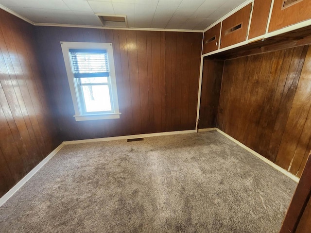 empty room featuring carpet floors and wooden walls