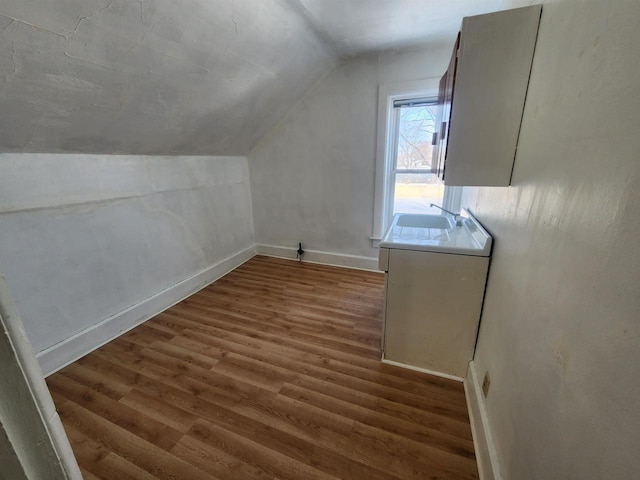 bonus room with lofted ceiling, dark hardwood / wood-style floors, and sink