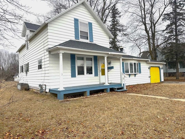 view of front facade featuring a porch, a garage, and a front yard