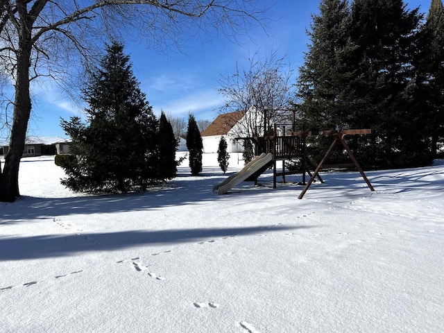 snowy yard featuring a playground