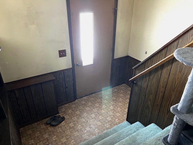 entrance foyer featuring a wealth of natural light and wooden walls