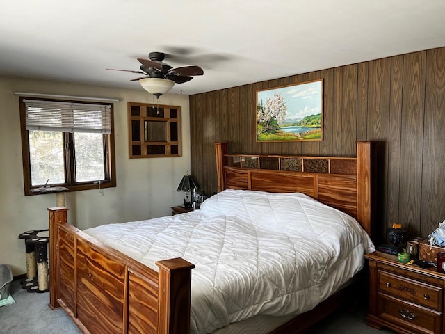 carpeted bedroom with wooden walls and ceiling fan