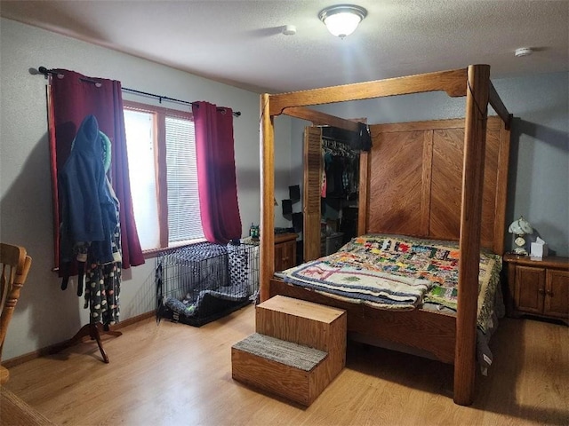 bedroom with light hardwood / wood-style floors and a textured ceiling