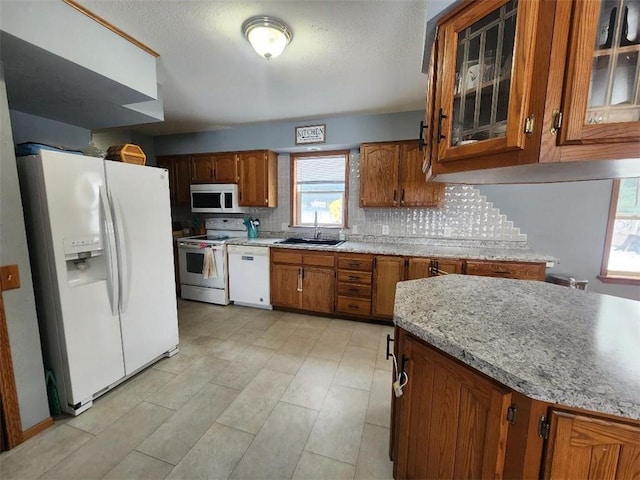 kitchen with tasteful backsplash, sink, and white appliances