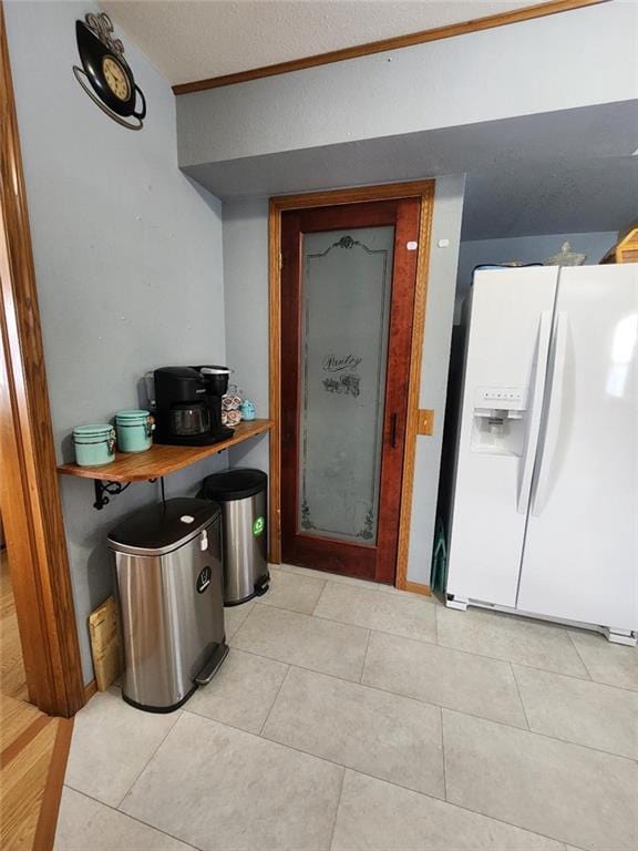 kitchen featuring white refrigerator with ice dispenser and light tile patterned floors