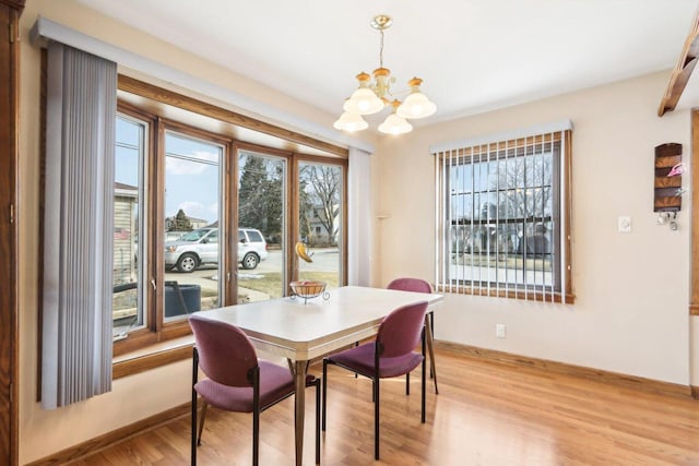 dining room with a notable chandelier and light wood-type flooring