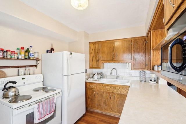 kitchen featuring dark hardwood / wood-style floors, sink, backsplash, and white appliances