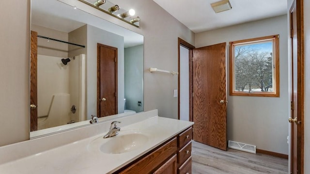 full bathroom featuring vanity, hardwood / wood-style flooring, shower / washtub combination, and toilet