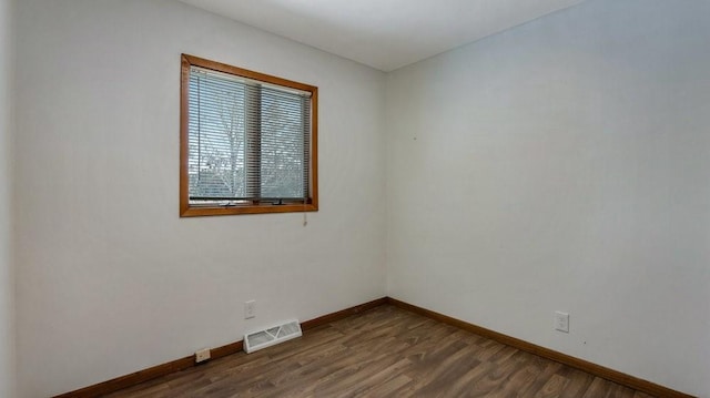 unfurnished room with dark hardwood / wood-style flooring