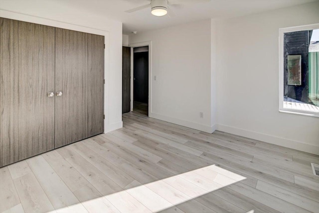 unfurnished bedroom featuring light hardwood / wood-style floors, ceiling fan, and a closet