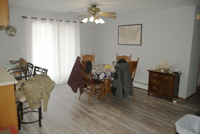 dining area with baseboard heating, ceiling fan, and hardwood / wood-style flooring