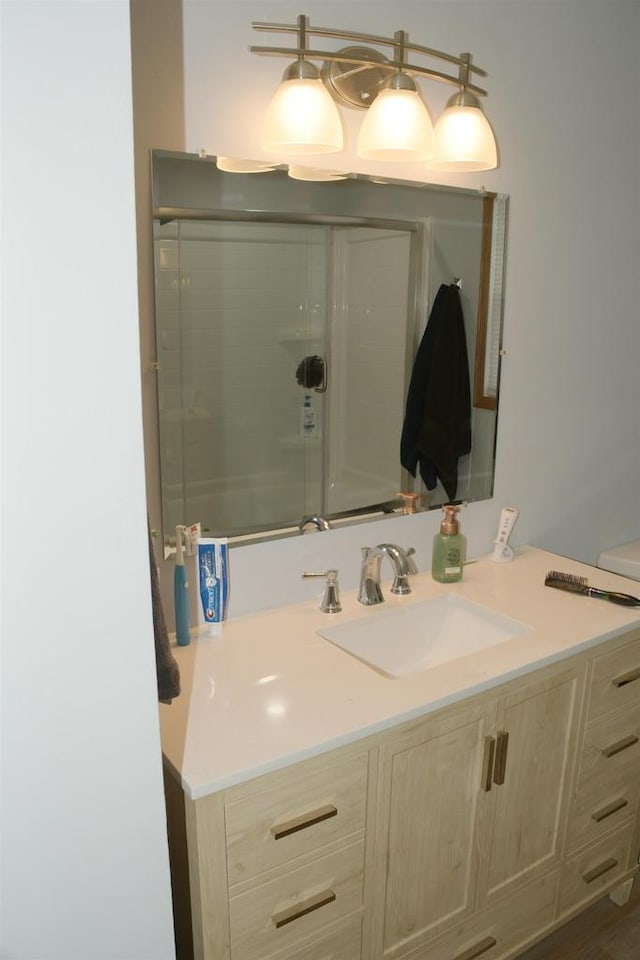 bathroom featuring vanity and a shower with shower door