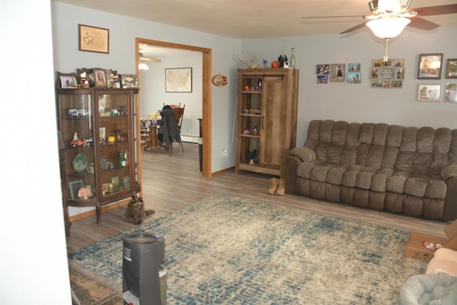 living room with hardwood / wood-style flooring, ceiling fan, and a baseboard heating unit