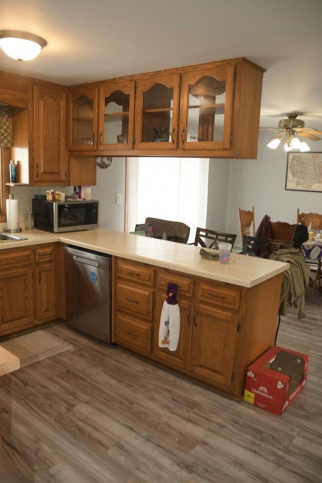 kitchen featuring sink, kitchen peninsula, hardwood / wood-style flooring, ceiling fan, and stainless steel appliances