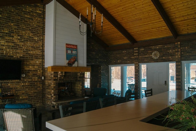 kitchen featuring beamed ceiling, brick wall, a fireplace, and high vaulted ceiling