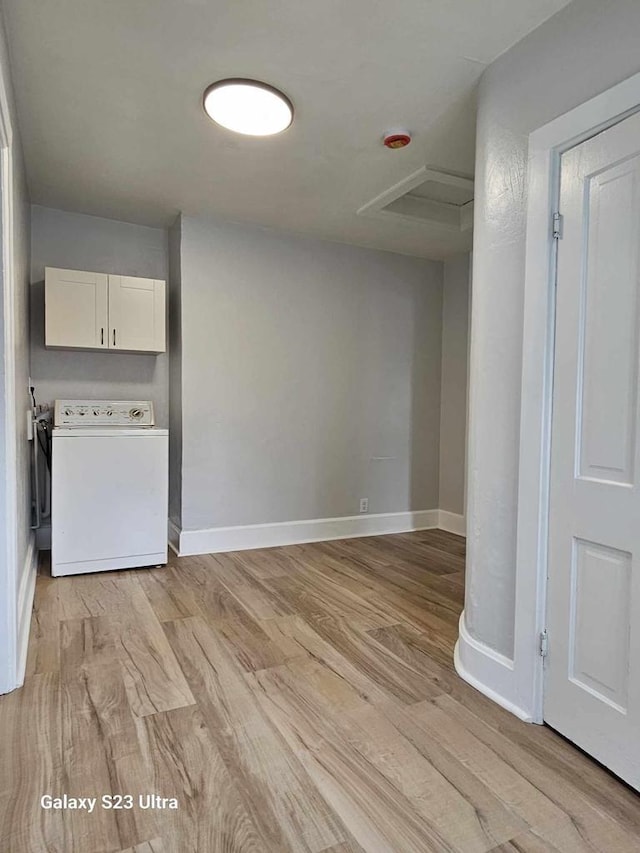 laundry room featuring washer / clothes dryer, cabinets, and light wood-type flooring