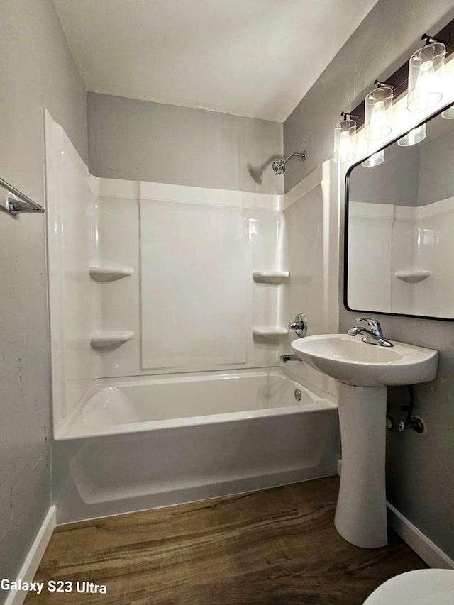 bathroom with wood-type flooring, toilet, and shower / bathing tub combination