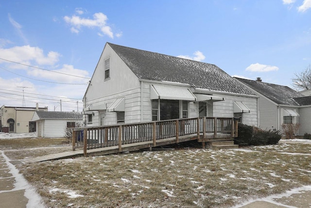 snow covered house with a wooden deck